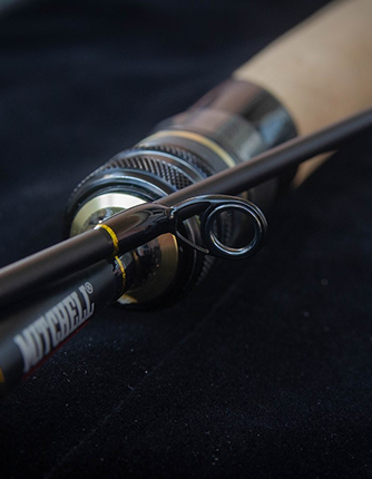 Close-up of a fishing rod with Mitchell branding on a dark background